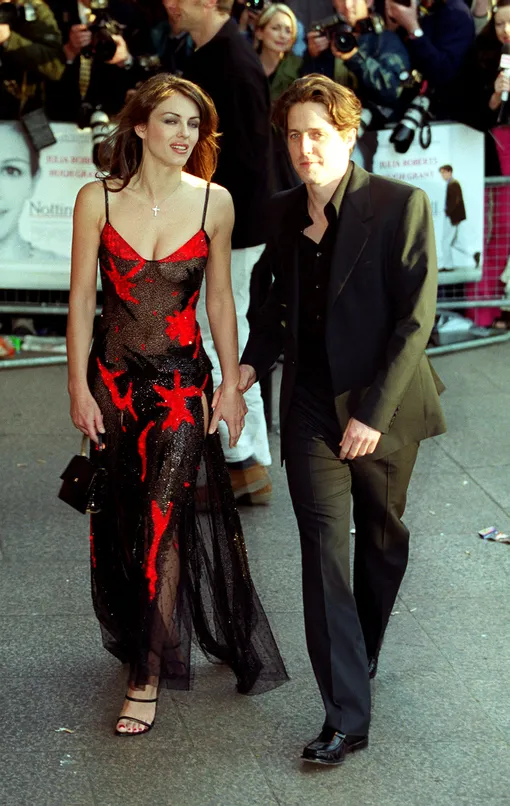 Model and film star, Elizabeth Hurley, wearing a Versace dress and film star Hugh Grant, arriving for the World Premiere of his new film, «Notting Hill», at the Odeon Leicester Square. КРЕДИТ